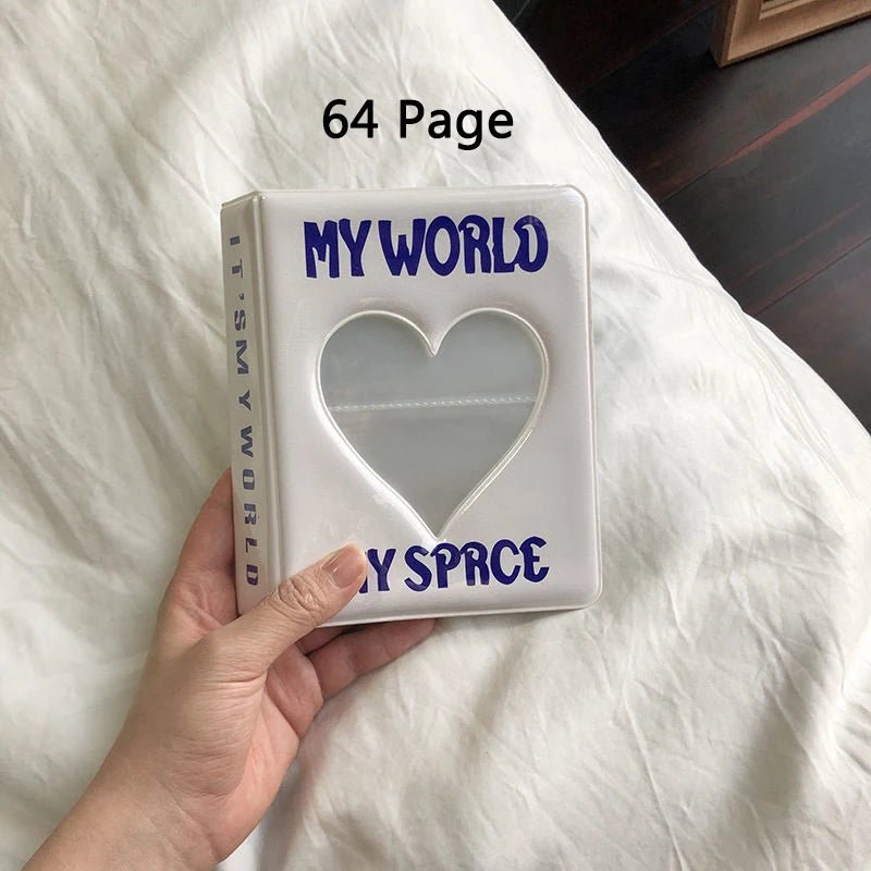 Photo album titled 'MY WORLD MY SPACE' with a heart cutout held by a hand on a white surface.