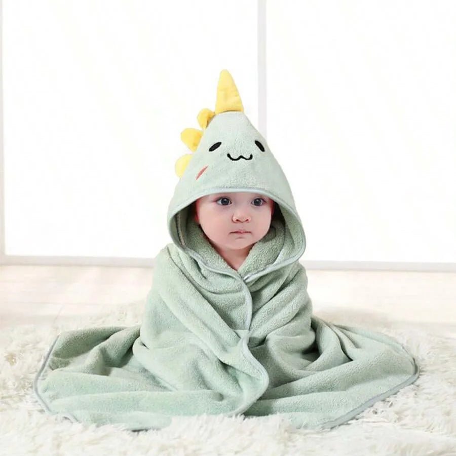 Child wearing a green hooded towel with a cartoon character design on a white background