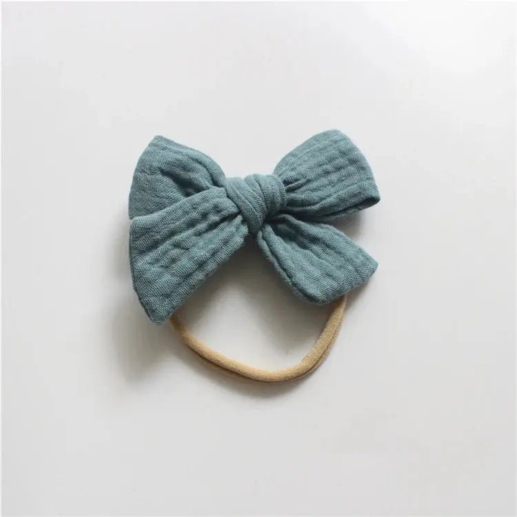 Blue bow headband on a light gray background