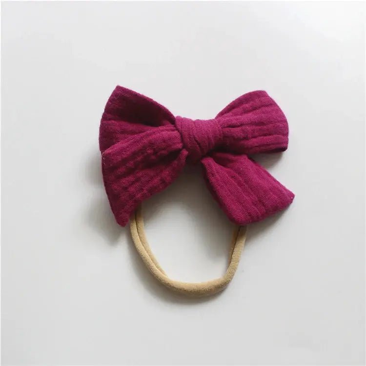 Pink bow headband on a light gray background