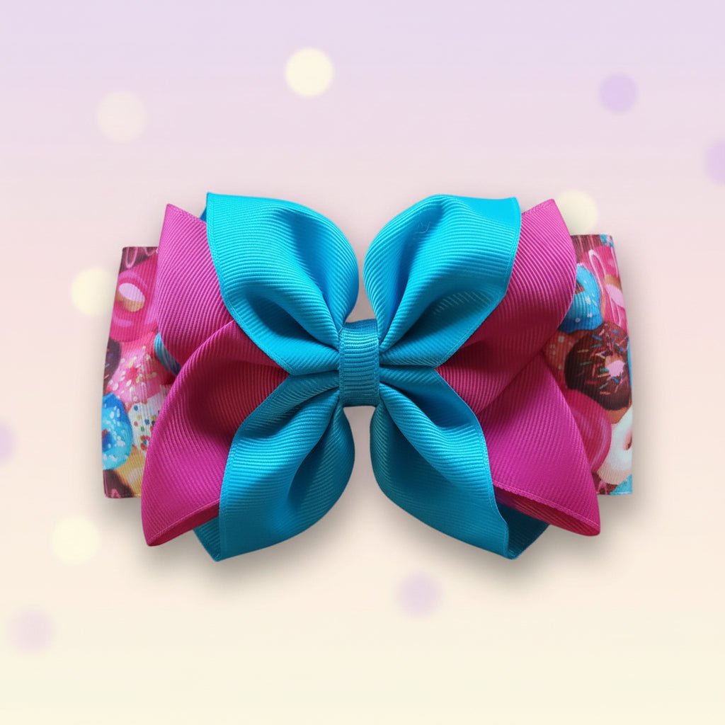A double-layered hair bow featuring a large turquoise blue center layer and a pink outer layer with a colorful donut print.