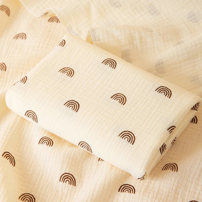 White pillow with brown rainbow patterns on a beige fabric background