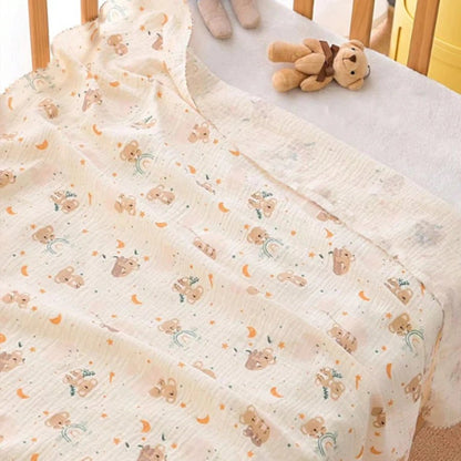 Baby crib with a soft, patterned blanket and a small teddy bear toy.