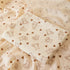 Baby blanket with teddy bear and heart pattern on a wooden surface