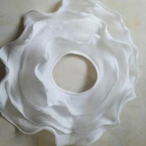 White ceramic sink drain cover on a light gray background