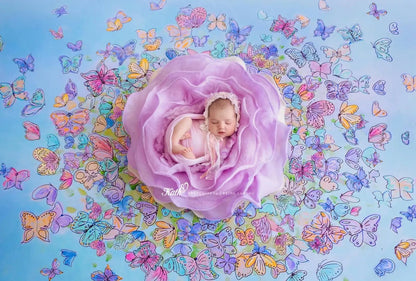 Newborn baby in a purple floral arrangement with colorful butterflies on a blue background