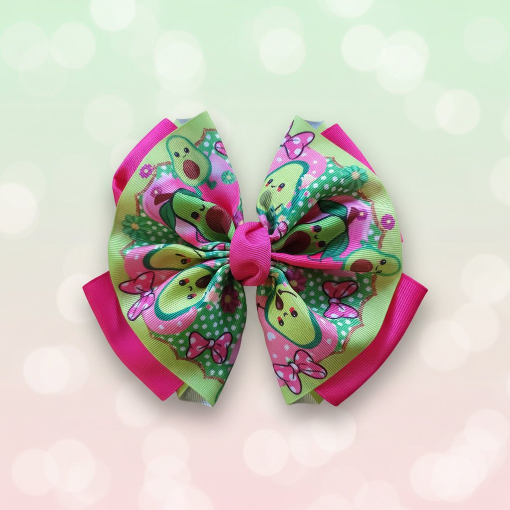 A colorful hair bow with a cartoon avocado pattern, pink trim, and a pink center