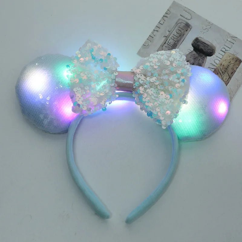 Light-up headband with sequin bow and colorful LED lights on a white background