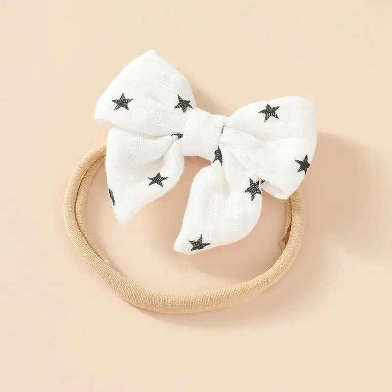 White bow with black star patterns on a beige background