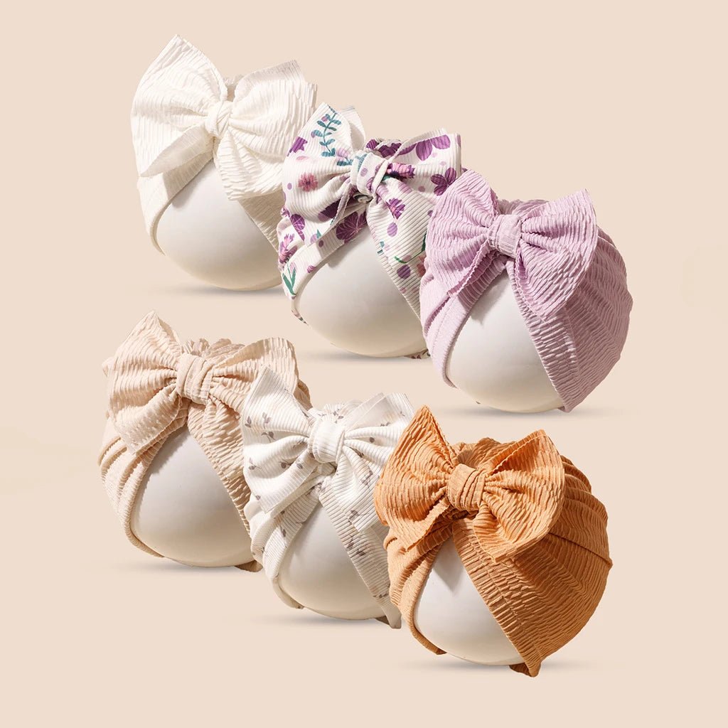 Set of colorful baby headbands with bows on a beige background
