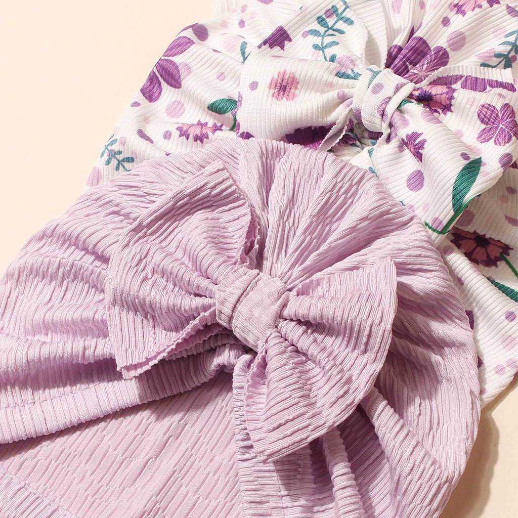 Pink textured headband with a bow and floral-patterned fabric in the background