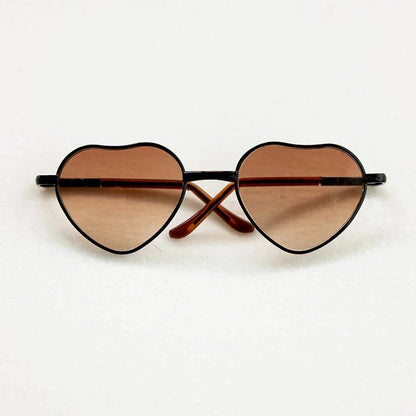 Heart-shaped sunglasses with brown lenses on a white background