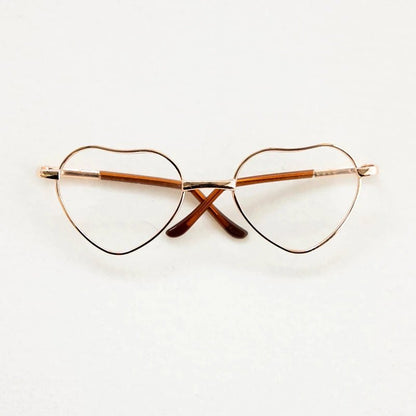 Heart-shaped eyeglasses with gold frame on a white background