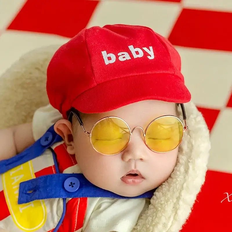 Baby wearing a red cap with &