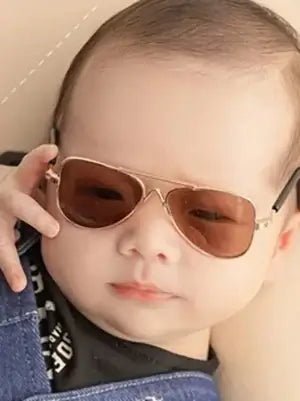 Child wearing brown sunglasses with a neutral background