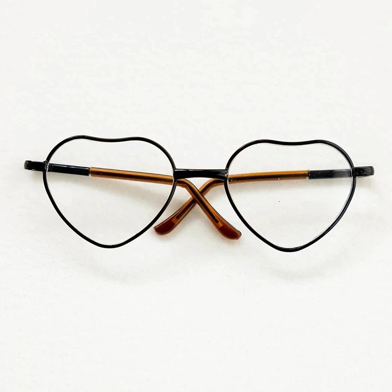 Heart-shaped eyeglasses with black frame and brown temple tips on a white background