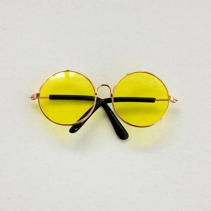 Round yellow sunglasses with gold frames on a light gray background