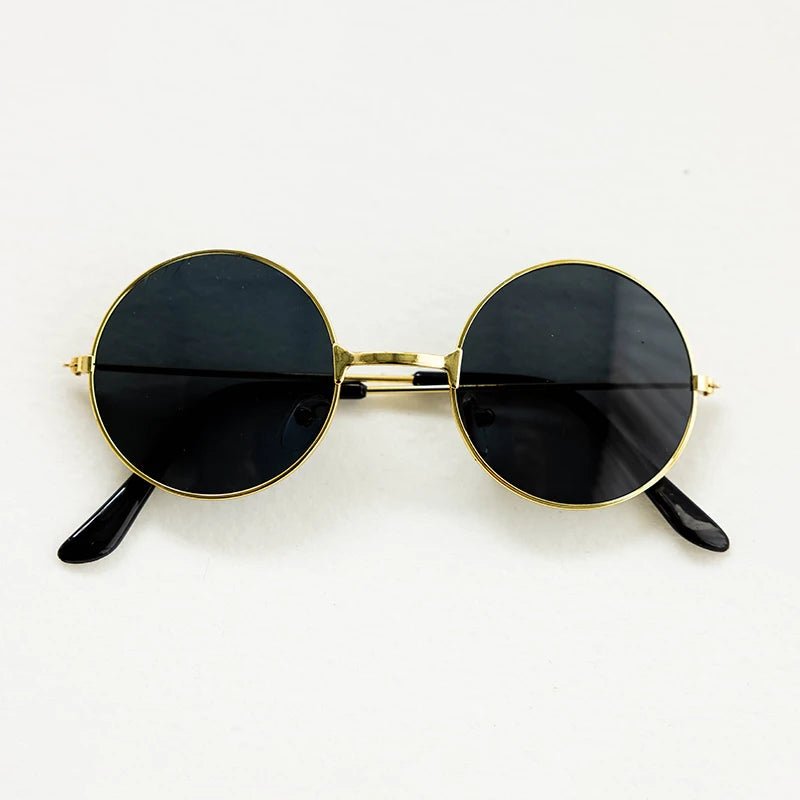 Round sunglasses with gold frames and black lenses on a white background
