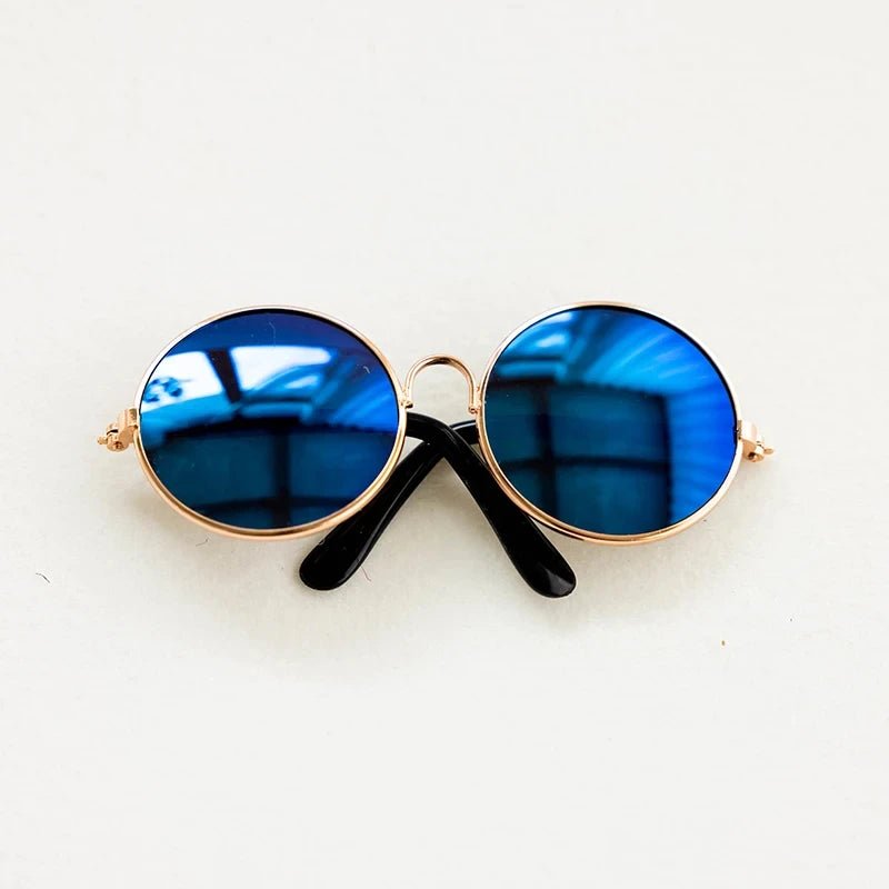 Round sunglasses with blue lenses and gold frames on a white background