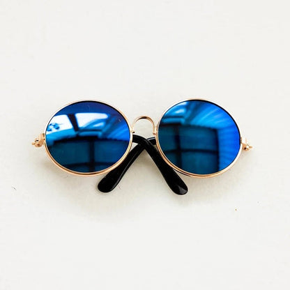 Round sunglasses with blue lenses and gold frames on a white background
