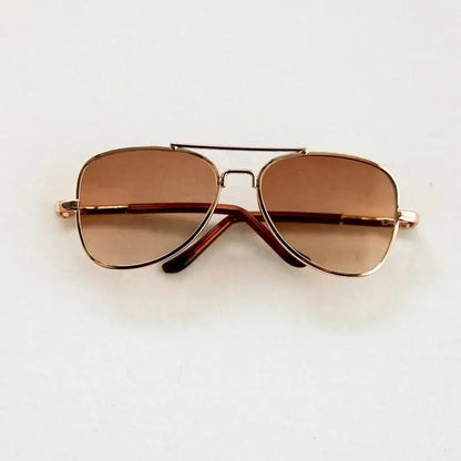 Aviator sunglasses with rose gold frame and brown lenses on a white background