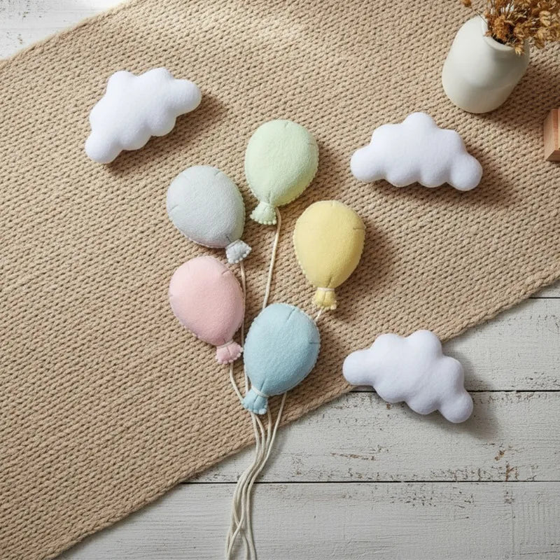 Decorative pastel-colored balloons and clouds on a textured surface