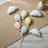 Decorative pastel-colored balloons and clouds on a textured surface