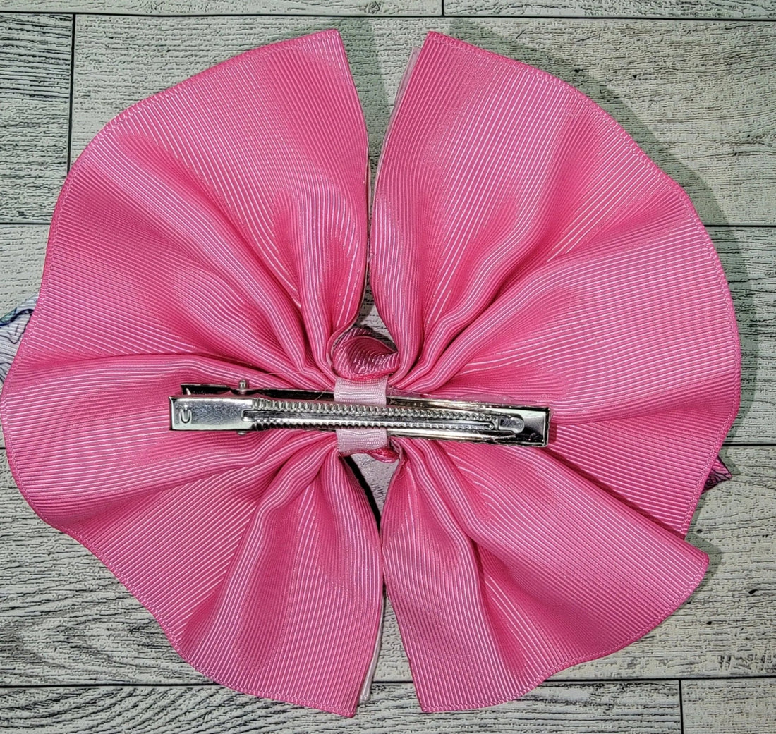 Pink bow with a zipper in the center on a wooden surface