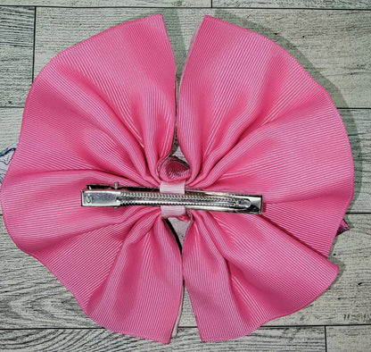 Pink bow with a zipper in the center on a wooden surface
