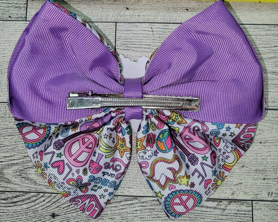 Purple hair bow with decorative base on a wooden surface, accompanied by a measuring tape.