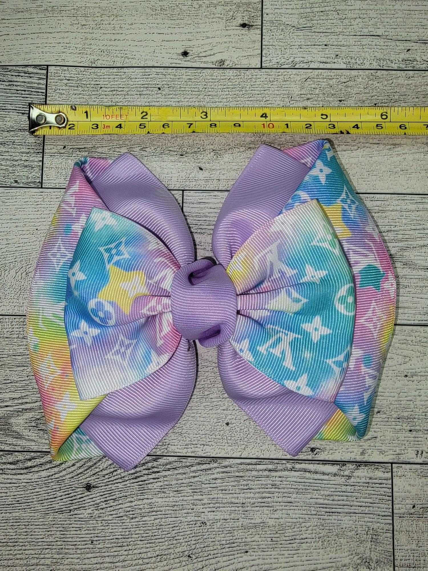 Colorful bow with a measuring tape on a wooden surface