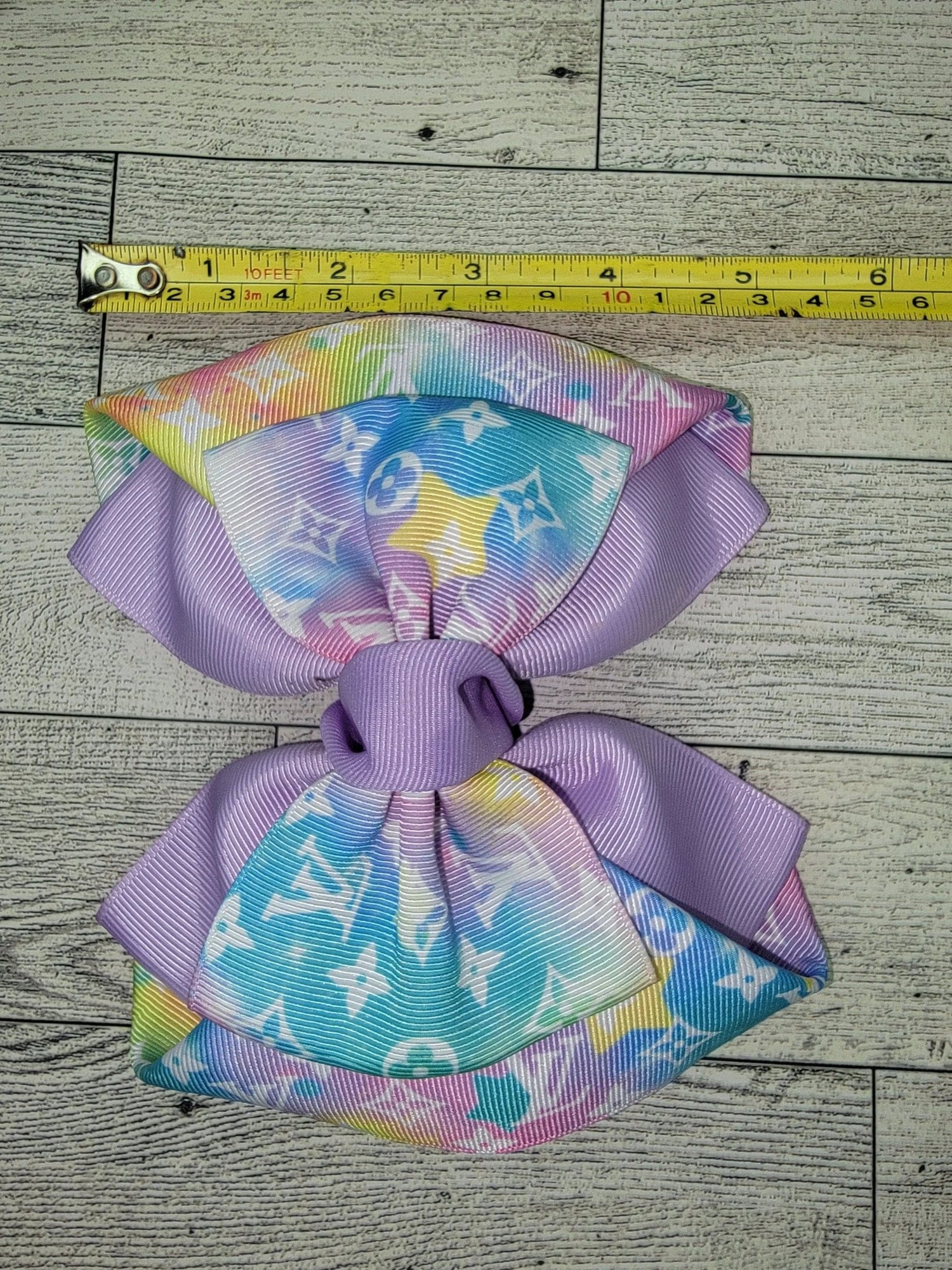 Colorful bow with a measuring tape on a wooden surface