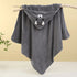 Gray hooded towel with animal face design on a wooden stick against a yellow background