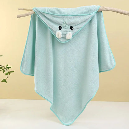 Light blue hooded towel with cartoon face on a branch against a beige background