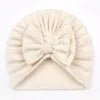 Beige turban with a bow on a plain background