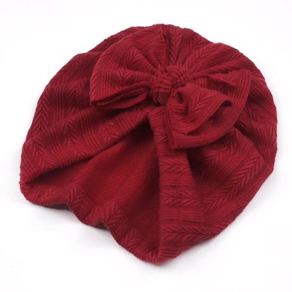 Red textured headband with a bow on a white background