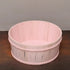 Pink wooden basket on a dark surface with a gray background