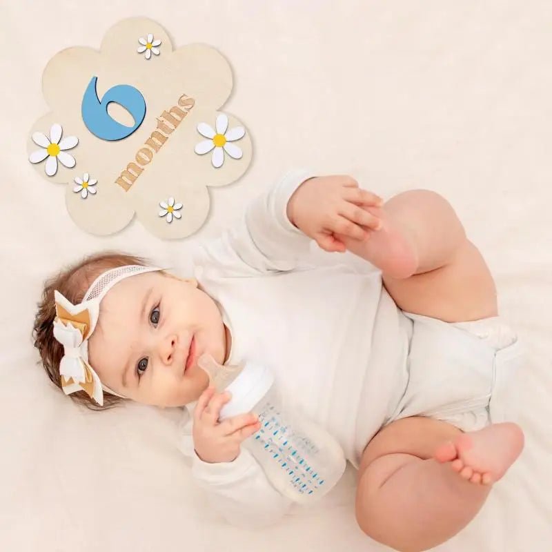 Baby lying on a white blanket with a &